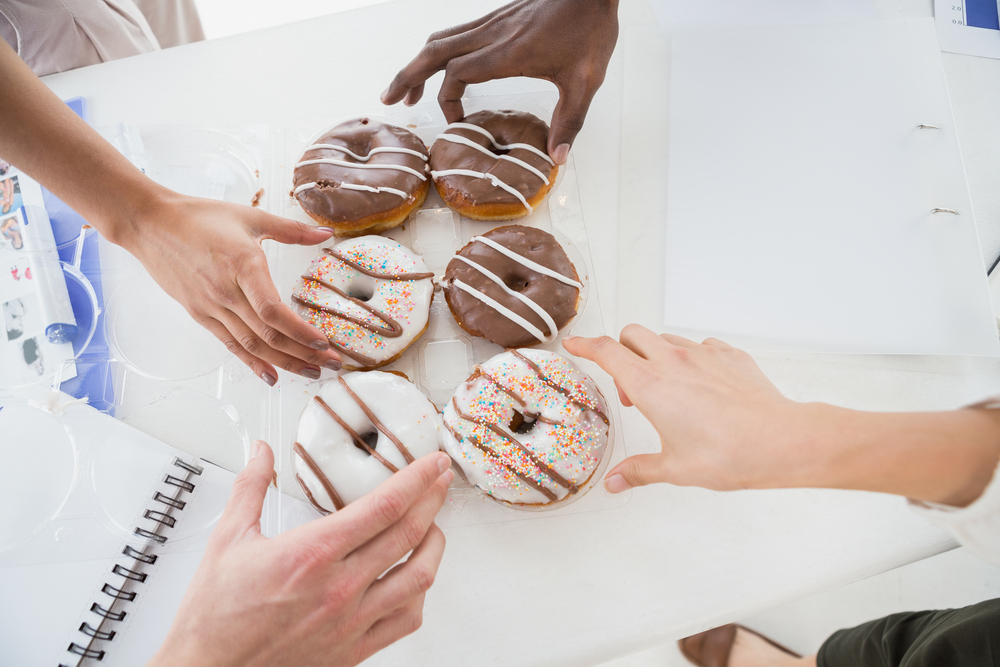 Business people taking doughnut at desk in the office
