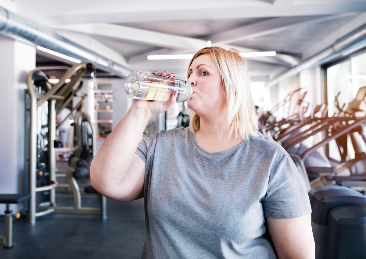 woman working out drinking water